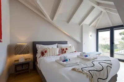 a white bedroom with a large bed with two towels on it at Boutique Rentals-Primrose Terrace&Garage in Porto