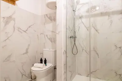 a white bathroom with a shower and a toilet at Campinho 1T - Stylish 1BR by LovelyStay in Porto