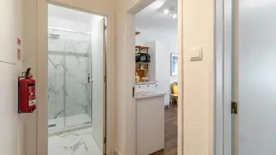 a bathroom with a walk in shower next to a kitchen at Campinho 1T - Stylish 1BR by LovelyStay in Porto