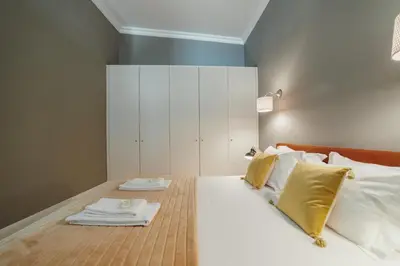 a bedroom with a bed with white sheets and yellow pillows at Downtown Excellence Apartment by Vacationy in Porto
