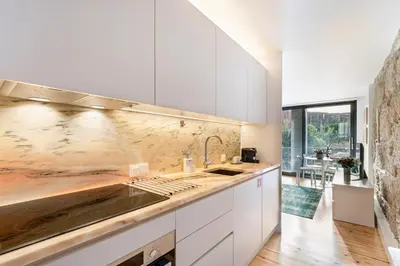 a kitchen with white cabinets and a counter top at Fontainhas Elite Apartments in Porto