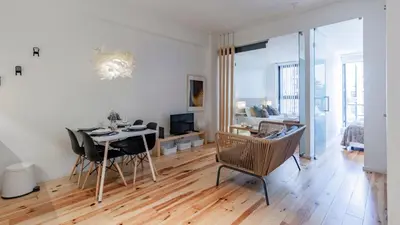 a living room with a table and chairs and a living room at Fernandes Tomás 424 by LovelyStay in Porto