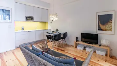 a living room with a couch and a table and a kitchen at Fernandes Tomás 424 by LovelyStay in Porto