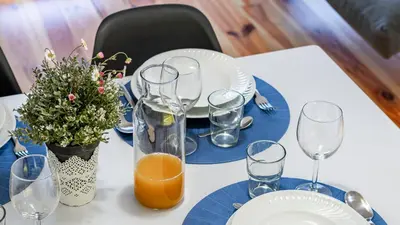 a table with glasses and plates and a vase with flowers at Fernandes Tomás 424 by LovelyStay in Porto