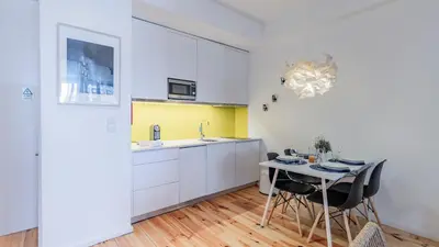 a kitchen with a table with chairs and a sink at Fernandes Tomás 424 by LovelyStay in Porto