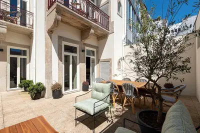 an outdoor patio with a wooden table and chairs at Ando Living - Santa Catarina House in Porto
