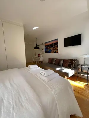 a white bedroom with a white bed and a couch at Historic Porto Balcony Hideaway - Taipas House 60 in Porto