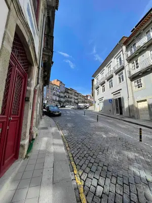 a cobblestone street with a red door on a building at Historic Porto Balcony Hideaway - Taipas House 60 in Porto