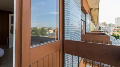 a kitchen with wooden cabinets and a stainless steel refrigerator at Central Gaia Apartment by Unique Hosts in Vila Nova de Gaia